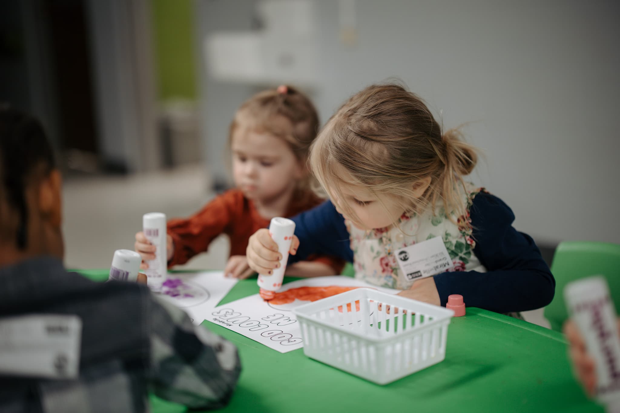 Two preschoolers dot-painting at a table in Kids Church.