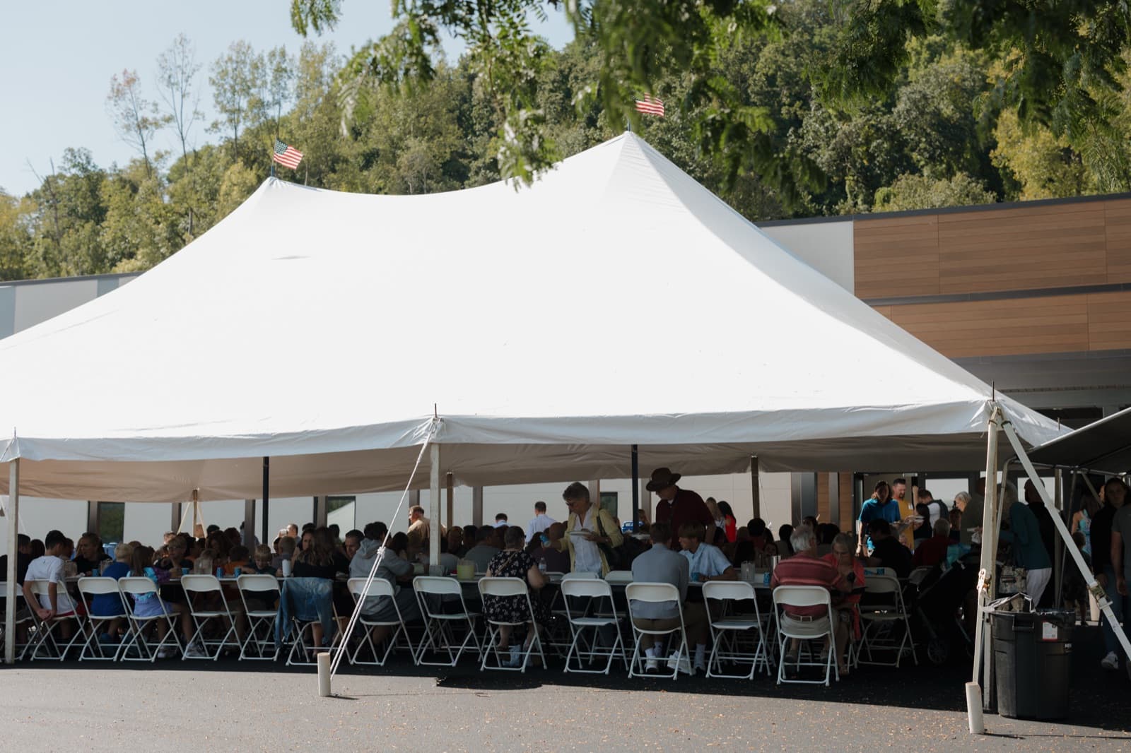People gathered outside under a tent for a Pleasant Valley Church event.