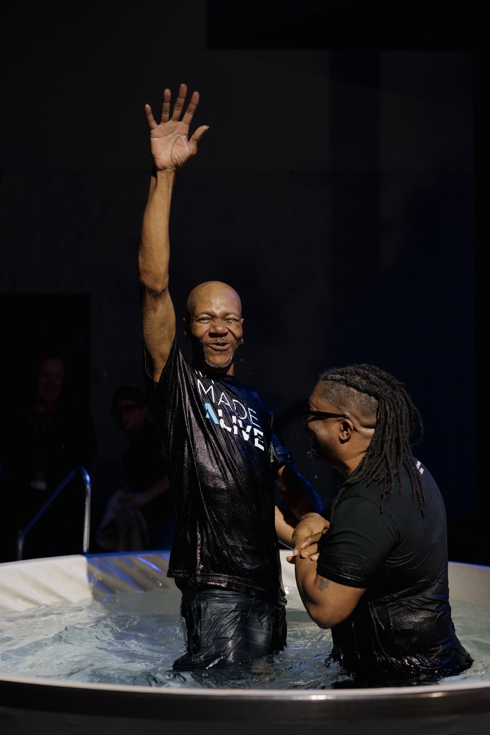 A man raising his hand in celebration after being baptized at Pleasant Valley Church.