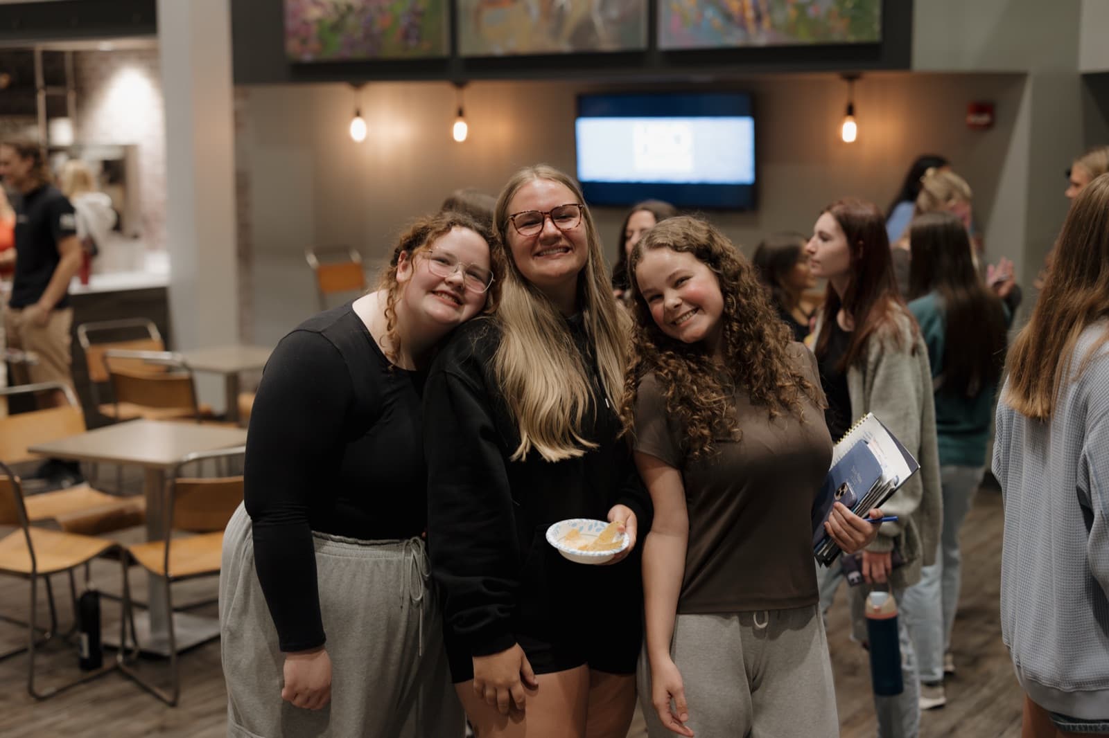 Three friends smiling together in the café.